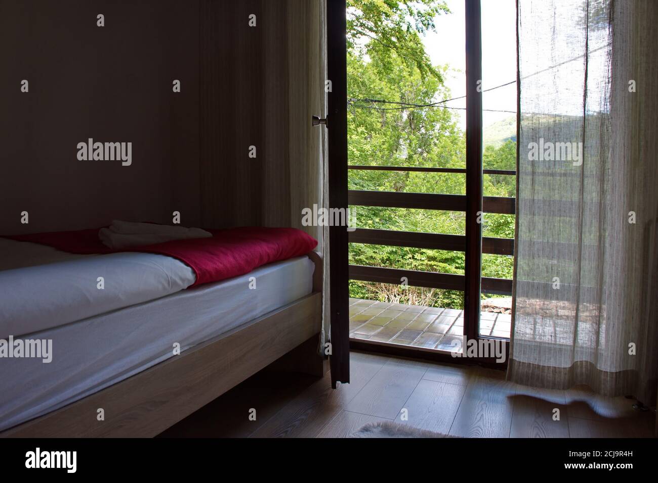 Dormitorio con luz desde el balcón Foto de stock