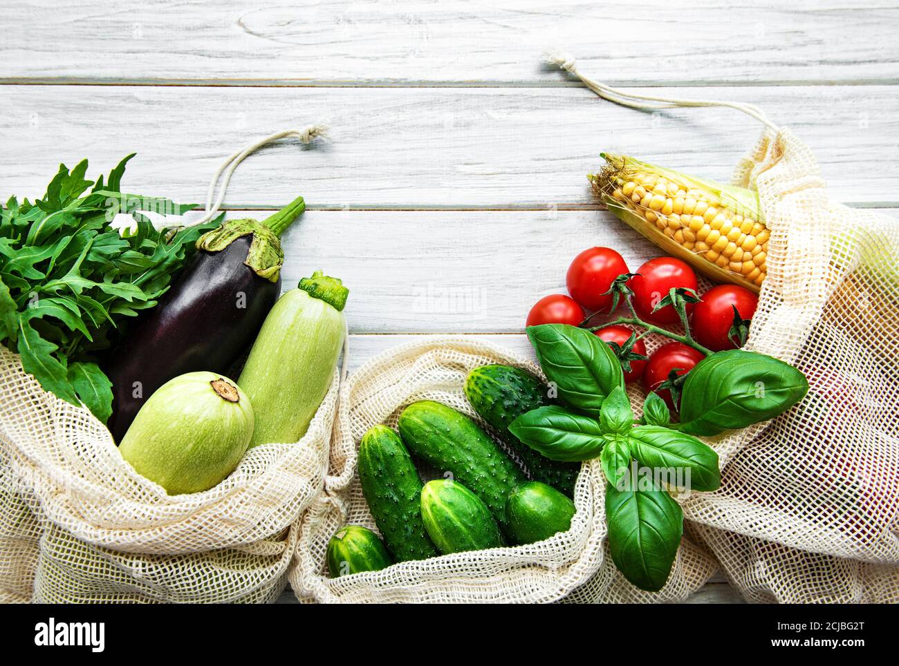 Verduras frescas en bolsas de algodón ecológico en la mesa de la cocina. Verduras frescas del mercado. Concepto de compras sin residuos. Foto de stock