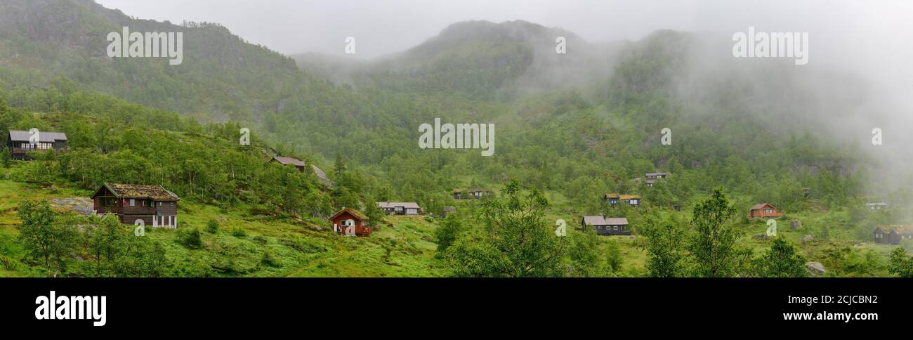 Casas de vacaciones de estilo noruego en las montañas brumosas del norte de Noruega. Foto de stock