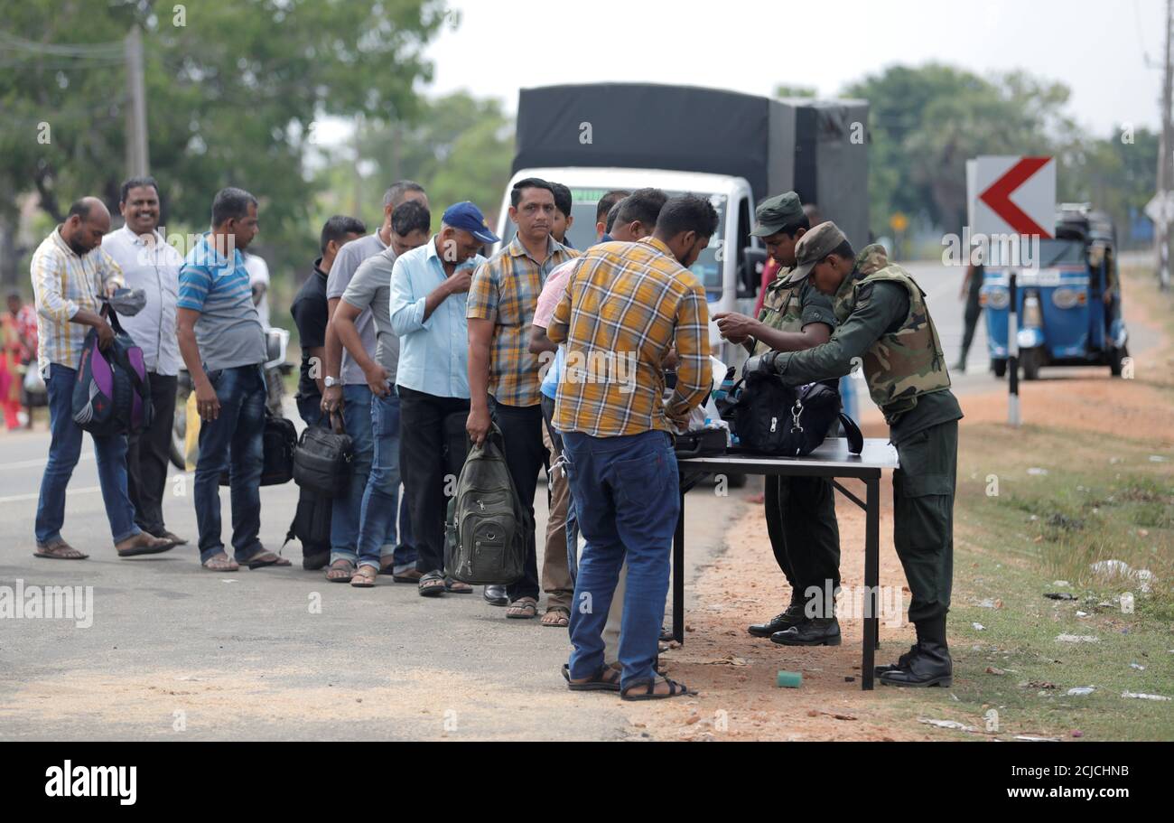El personal del ejército de Sri Lanka busca a personas y sus bolsos en un punto de control en la aldea de Kattankudy, Sri Lanka, 28 de abril de 2019. REUTERS/Dinuka Liyanawatte Foto de stock