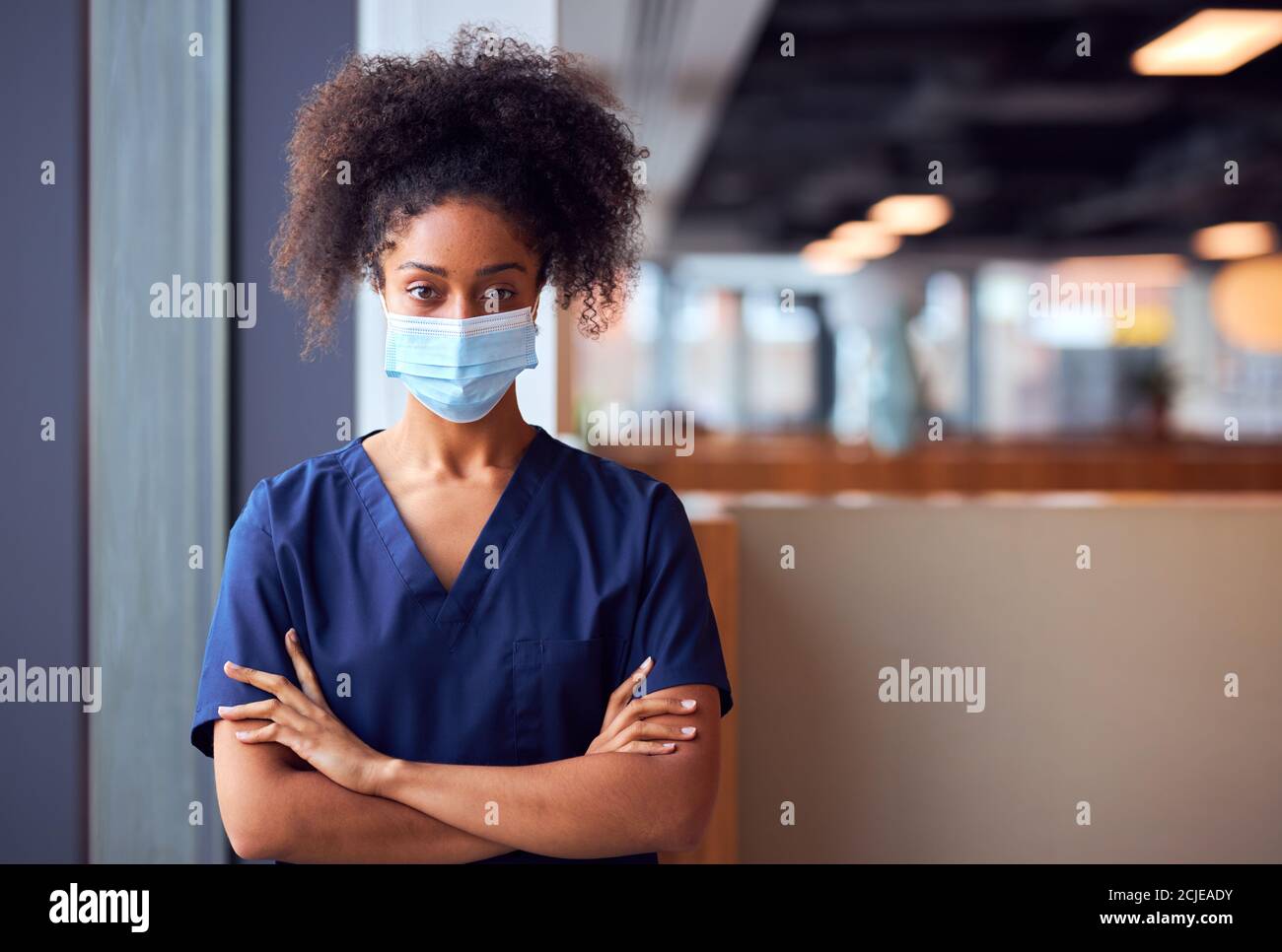 Mujer Doctora en máscara facial usando exfoliantes bajo presión en Hospital ocupado durante una pandemia de salud Foto de stock