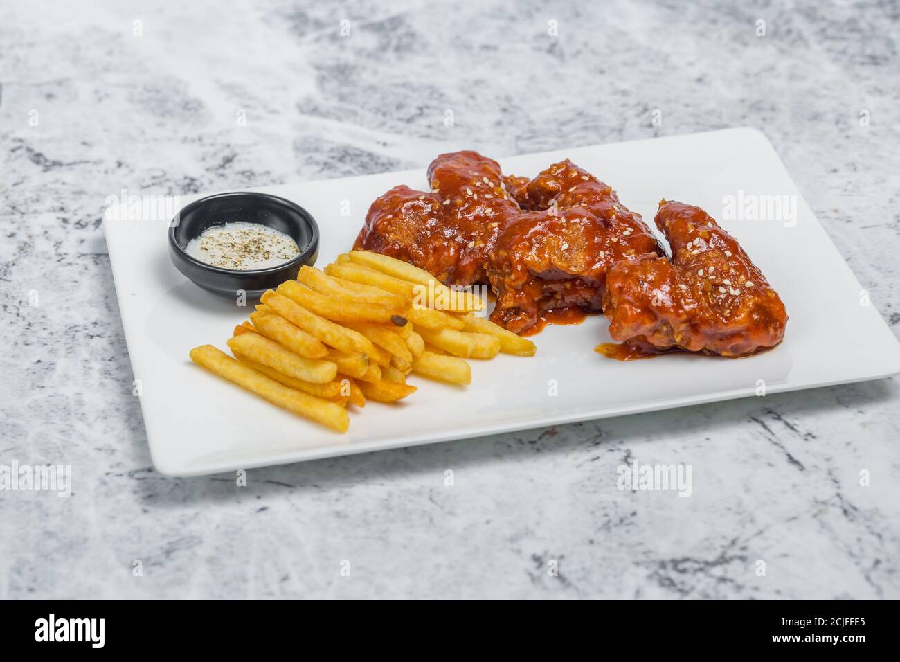 Alitas de pollo de búfalo picante y patatas fritas crujientes con salsa  blanca Fotografía de stock - Alamy