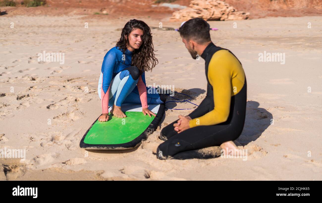 Pareja de surfistas con traje de baño y preparándose para el surf  Fotografía de stock - Alamy