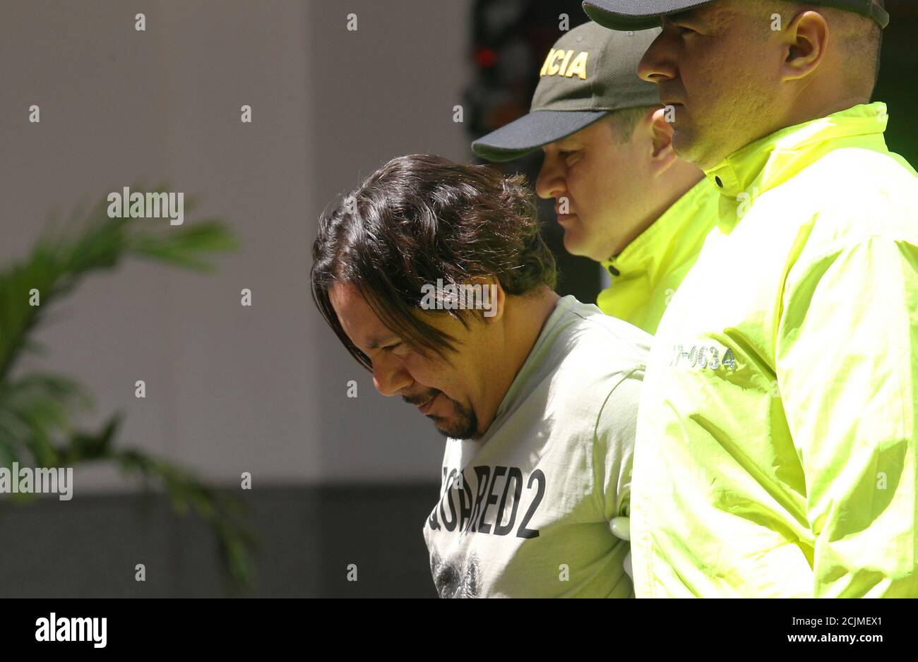 Juan Carlos Mesa Vallejo, también conocido como "Tom", es acompañado por  agentes de policía durante una presentación de prensa en la sede de la  Policía en Medellín, Colombia, el 9 de diciembre