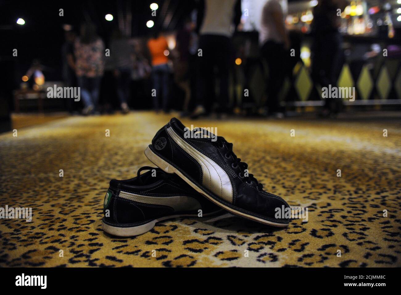 Zapatos de boliche de diez bolos - Marca Puma tamaño 8 en una alfombra de  patrón de leopardo en una bolera Fotografía de stock - Alamy