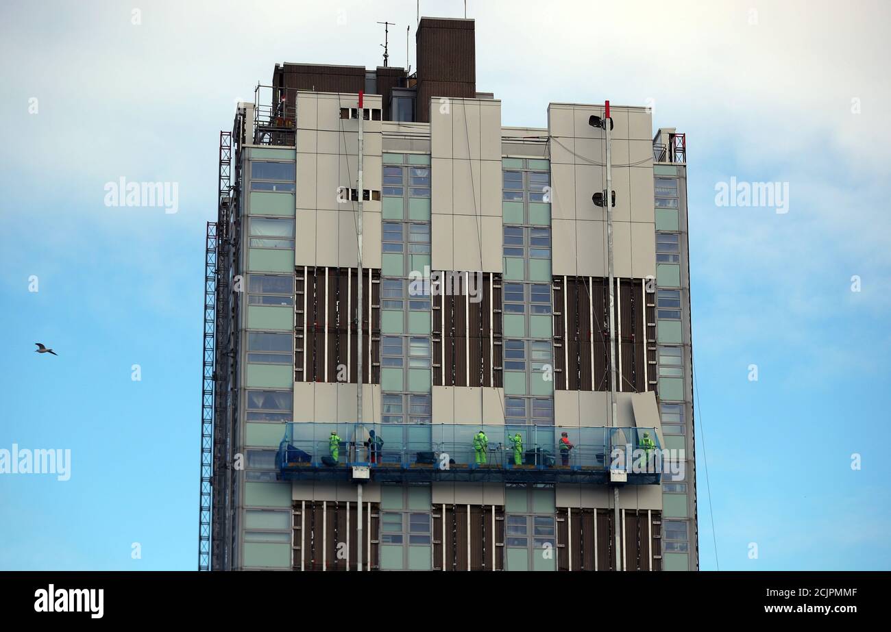 Los trabajadores sacan el revestimiento del bloque residencial de Blashford Tower en la finca Chalcots en el norte de Londres, Gran Bretaña, 30 de noviembre de 2017. Foto tomada el 30 de noviembre de 2017. REUTERS/Hannah McKay Foto de stock