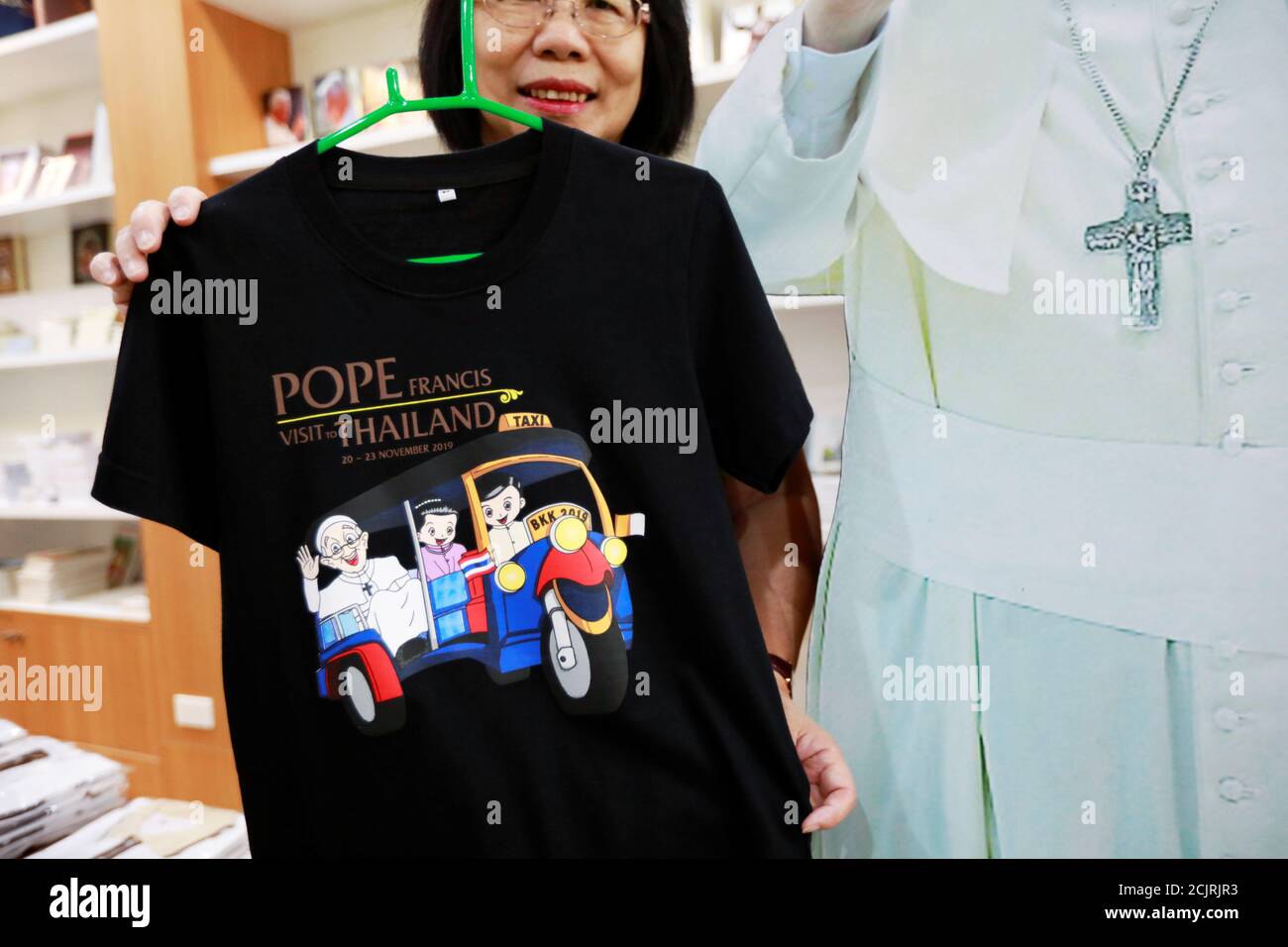 Una mujer sostiene una camiseta que representa al Papa Francisco en una  tienda de recuerdos en Bangkok, Tailandia, el 6 de noviembre de 2019.  REUTERS/Soe Zeya Tun Fotografía de stock - Alamy