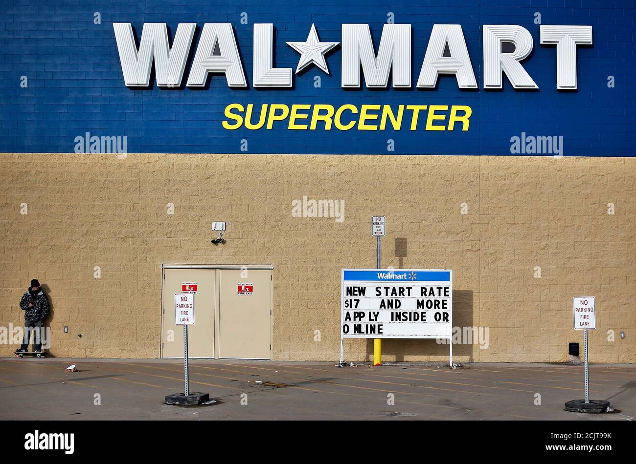 Un hombre está de pie en un monopatín fuera de una tienda Wal-Mart en Williston, Dakota del Norte 13 de marzo de 2013. Wal-Mart ha cobrado alrededor de $2.7 mil millones en cheques de reembolso de impuestos en sus tiendas de EE.UU. Hasta ahora este año, dijo el director financiero Charles Holley en una conferencia de inversionistas que fue transmitida a través de Internet. En este momento, el año pasado, esa cantidad era de unos 4.000 millones de dólares. REUTERS/Shannon Stapleton (ESTADOS UNIDOS - Tags: BUSINESS EMPLOYMENT) Foto de stock