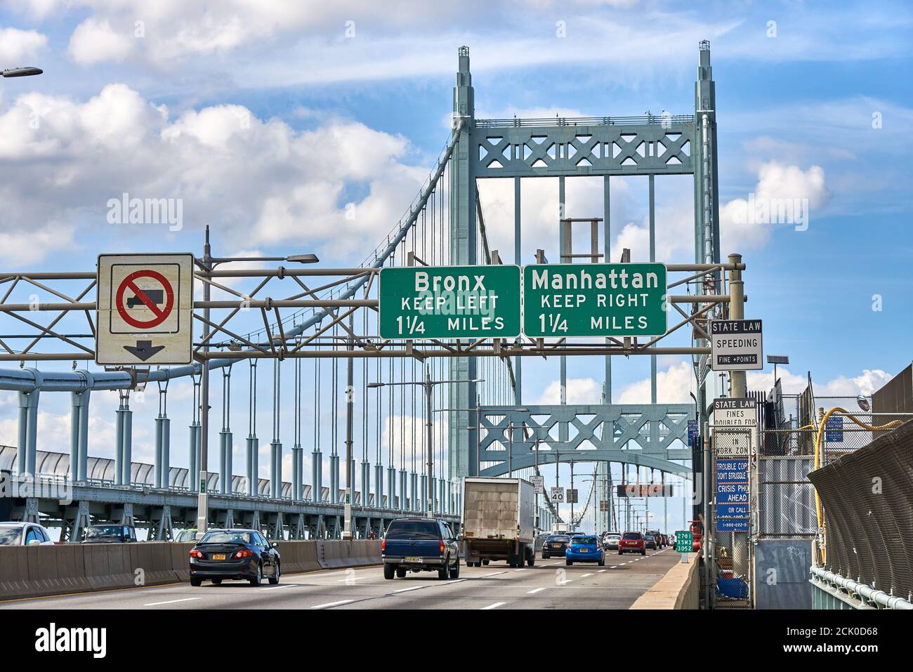 Autos y camiones cruzando el puente Robert F Kennedy, con señales para salidas al Bronx y Manhattan. Foto de stock