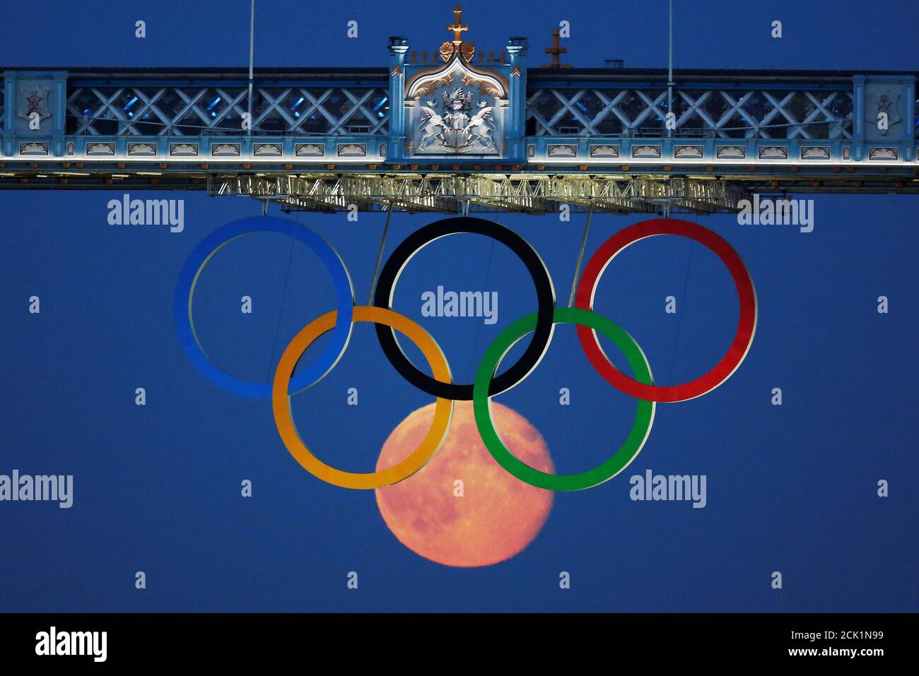 La luna llena se eleva a través de los anillos olímpicos que cuelgan debajo  del puente de la torre durante los Juegos Olímpicos de Londres 2012 en Gran  Bretaña, 3 de agosto