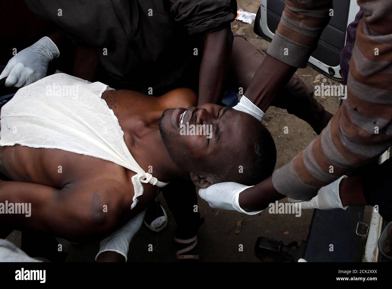 Los médicos evacuan a un manifestante herido durante enfrentamientos entre partidarios del líder de la oposición Raila Odinga y policías antidisturbios, en Mathare, Nairobi, Kenya, 12 de agosto de 2017. REUTERS/Thomas Mukoya Foto de stock