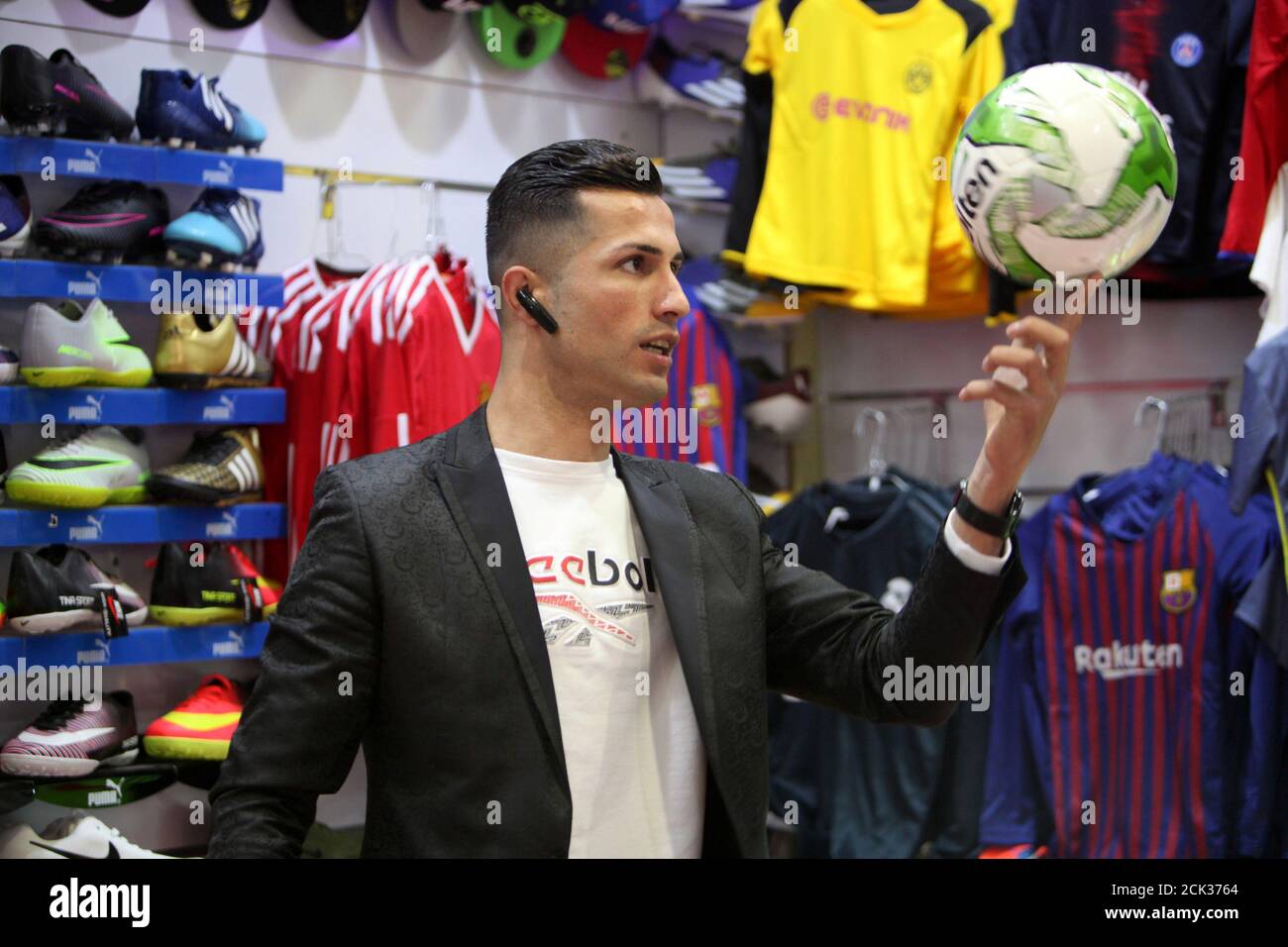 Biwar Abdullah, de 25 años, un futbolista local kurdo iraquí, que se parece  al futbolista Cristiano Ronaldo, posan para una fotografía en una tienda de  ropa deportiva en el distrito de Soran,