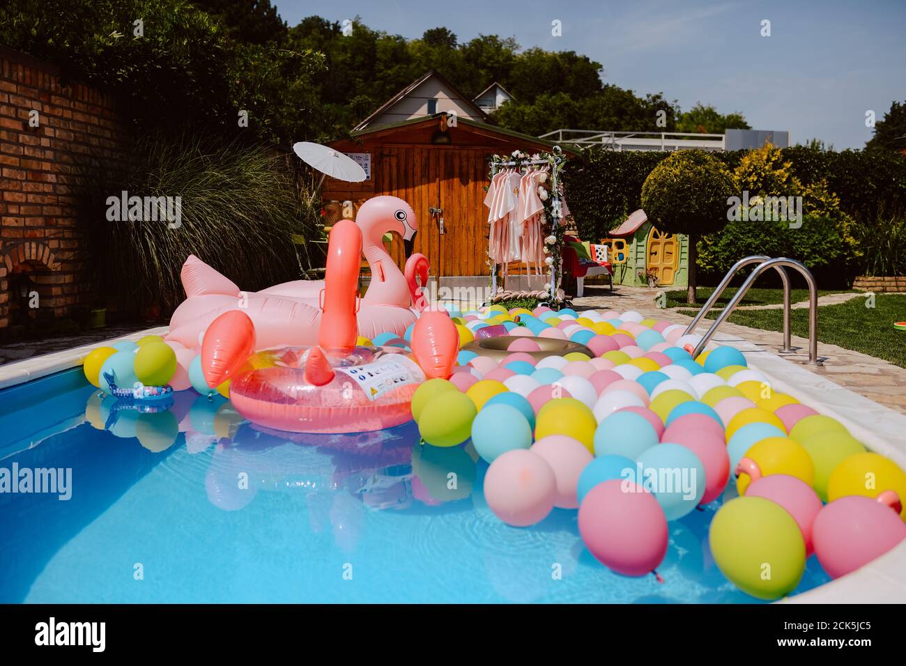 Patio hermosamente con globos de piscina y flamencos rosados. Decoración de jardín de verano Fotografía de stock - Alamy