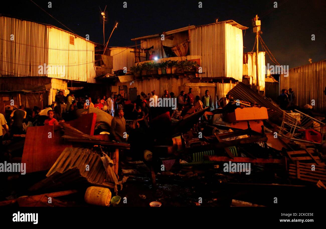 Los residentes se reúnen cerca de sus pertenencias salvadas mientras sus casas se queman en un incendio que estalló en los barrios de tugurios de Kijiji en la propiedad Southlands de Nairobi, Kenia, el 28 de enero de 2018. REUTERS/Thomas Mukoya Foto de stock