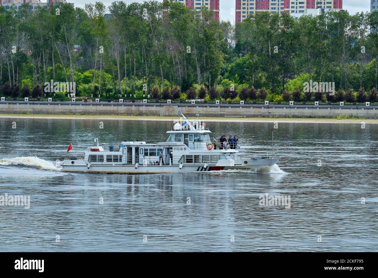 Blagoveshchensk, Rusia - Jun 26, 2020: Barco chino en el río Amur frente a la ciudad de Heihe. Vista desde el terraplén de la ciudad de Foto de stock