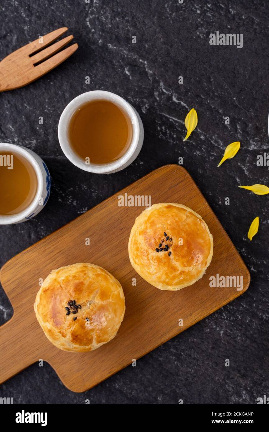 Tarta de luna pastel de yema, pastel de luna para las vacaciones del Festival de mediados de Otoño, vista superior concepto de diseño en mesa de madera oscura con espacio de copia, laico plano, tiro al techo Foto de stock