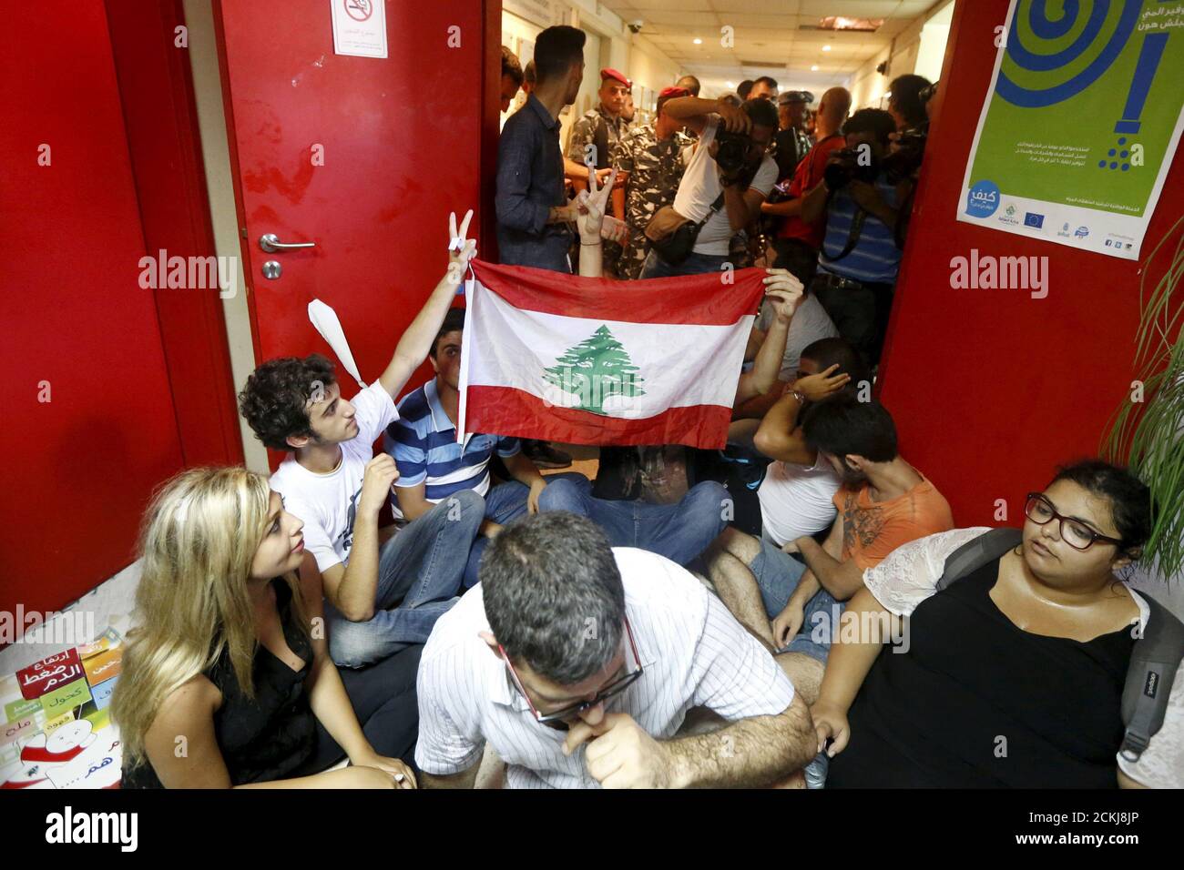 Los manifestantes llevan una bandera libanesa dentro del Ministerio de Medio Ambiente en el centro de Beirut, Líbano 1 de septiembre de 2015. Docenas de manifestantes ocuparon el Ministerio de Medio Ambiente en la capital libanesa Beirut el martes pidiendo al ministro Mohamad al Machnouk que dimita por una crisis de eliminación de basura, la última de una ola de protestas contra el sistema político paralizado. Cientos de otros manifestantes se reunieron fuera del edificio mientras la policía antidisturbios tomó posiciones en las calles de los alrededores y la campaña antigubernamental "You Stink" convocó una nueva manifestación en una plaza cercana por la tarde. REUTERS/Mohamed Foto de stock