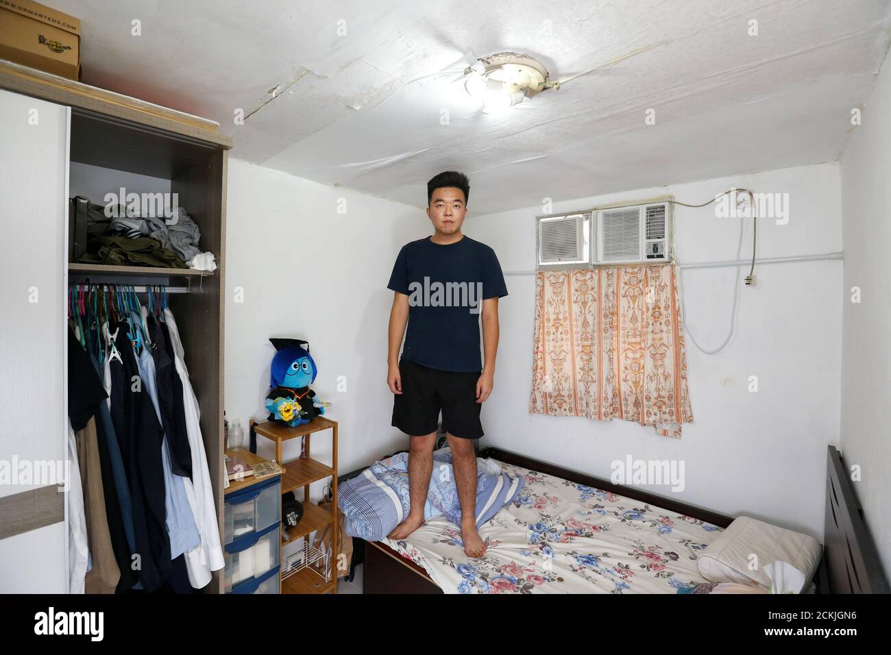 Roy Lam, residente nativo de Hong Kong, de 23 años, que trabaja en HR, y vive con su madre y cuatro hermanas, se presenta para una foto en su dormitorio de 7 metros cuadrados del apartamento de su familia en Hong Kong, China, el 30 de junio de 2019. "Más bien perdemos estar de pie que perder sentarnos", dijo Lam. Añadió que los jóvenes estaban decididos a defender lo que se merecía, pero era difícil mantenerse positivos. "A veces también pensamos que "vamos a renunciar, vamos a mudarnos a otro lugar". REUTERS/Thomas Peter BUSCA 'YOUNG HK' PARA ESTA HISTORIA. BUSQUE "IMAGEN MÁS AMPLIA" PARA TODAS LAS HISTORIAS. Foto de stock