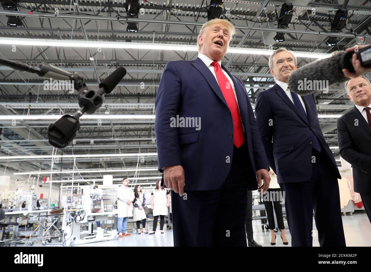 El presidente estadounidense Donald Trump habla a la prensa junto al  presidente y director general del grupo de productos de lujo LVMH Bernard  Arnault de Louis Vuitton durante su visita al taller