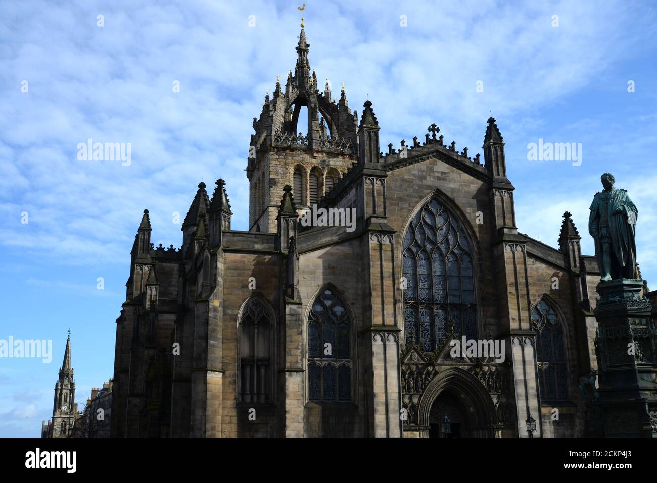 Iglesia histórica de St Giles en la Royal Mile Edinburgh en el soleado día con el cielo azul profundo y las nubes blancas wispy mostrando estatuas y vidrieras Foto de stock