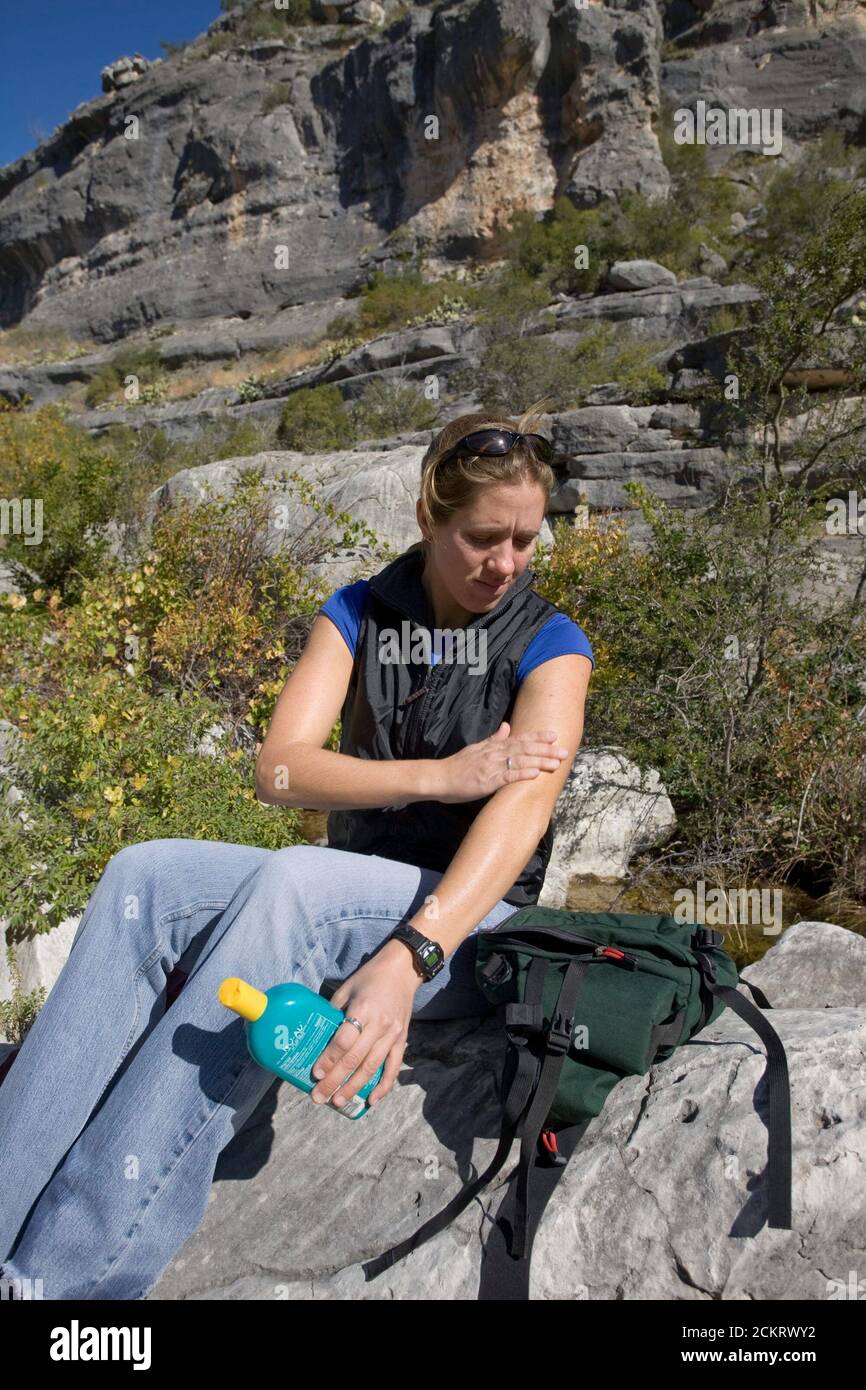 Comstock, TX: 15 de noviembre de 2008. El excursionista femenino aplica protector solar en un día brillante en el remoto Cañón de Dead Man a lo largo del río Pecos en una zona escarpada en el condado de Val Verde. ©Bob Daemmrich Foto de stock