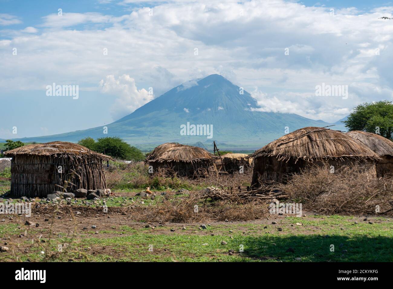 Pueblo tradicional Maasai con cabañas de arcilla redonda en la zona de Engare Sero cerca del Lago Natron y el volcán Ol Doinyo Lengai en Tanzania, África Foto de stock