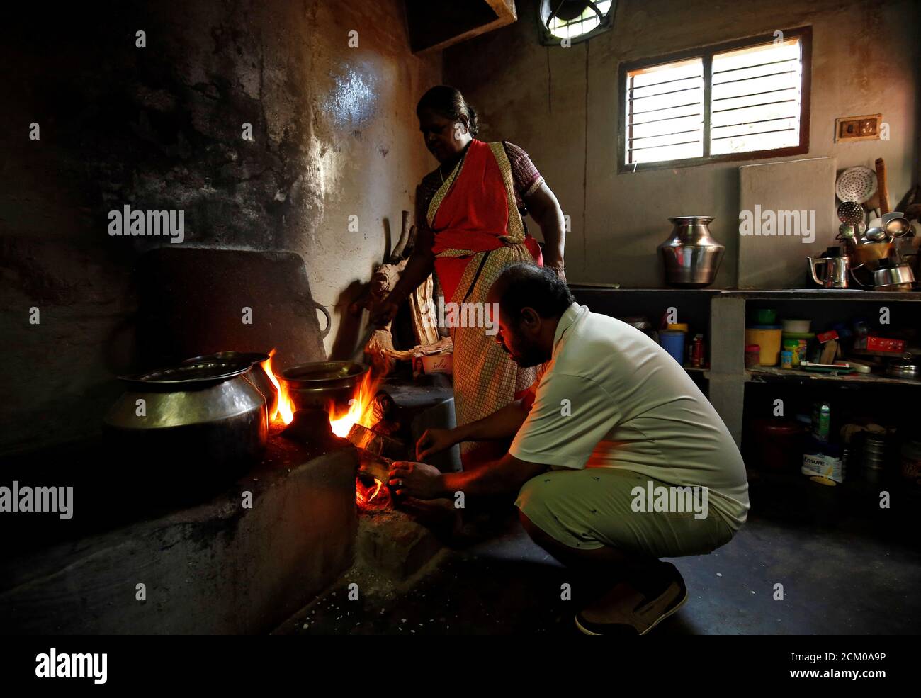 Karibeeran Paramesvaran (frente), que perdió a tres niños en el tsunami de 2004, ayuda a cocinar alimentos dentro de su casa que se ha convertido en un hogar de cuidado para niños huérfanos en el distrito de Nagapattinam en el estado sureño de Tamil Nadu, India, 4 de diciembre de 2019. Foto tomada el 4 de diciembre de 2019. REUTERS/P. Ravikumar Foto de stock