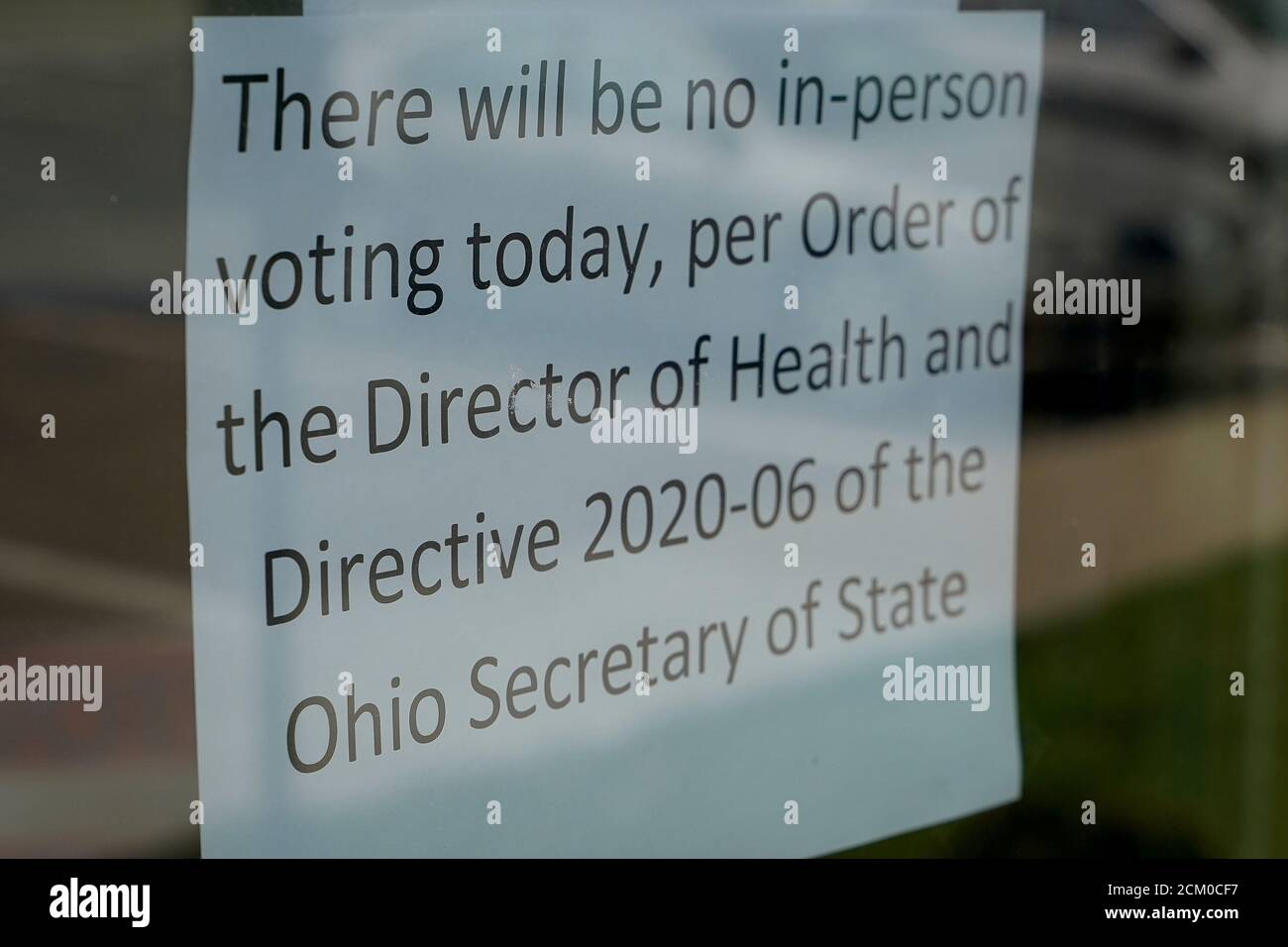 Un cartel se encuentra en la puerta cerrada de la Junta Electoral del Condado de Hamilton después de que el gobernador de Ohio Mike DeWine ordenara que el día de las elecciones se pospusiera para frenar la propagación de la nueva enfermedad del coronavirus (COVID-19), en Cincinnati, Ohio, EE.UU. 17 de marzo de 2020. REUTERS/Bryan Woolston Foto de stock