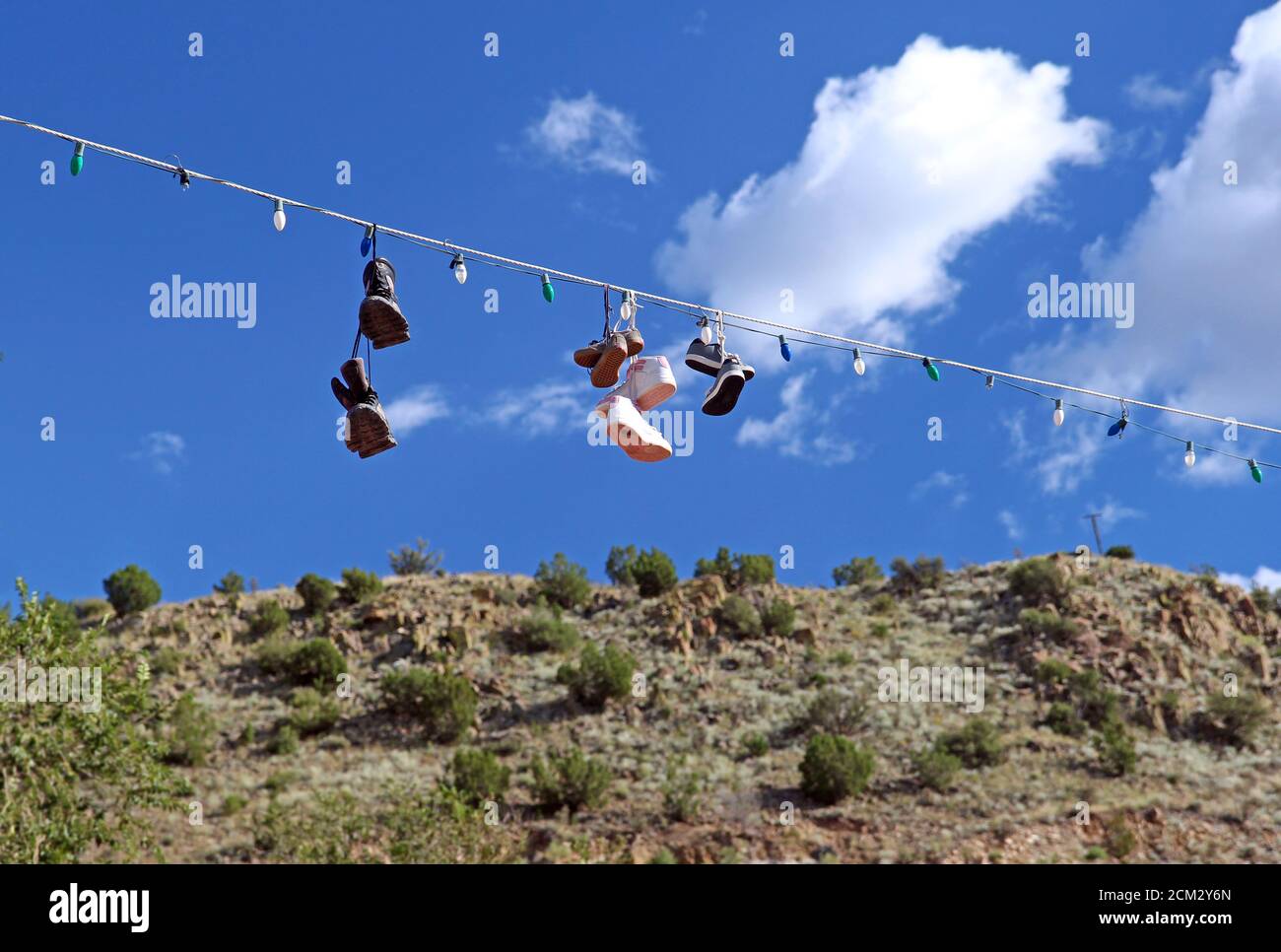 Zapatillas de lona colgando de una cadena de luces Fotografía de stock -  Alamy