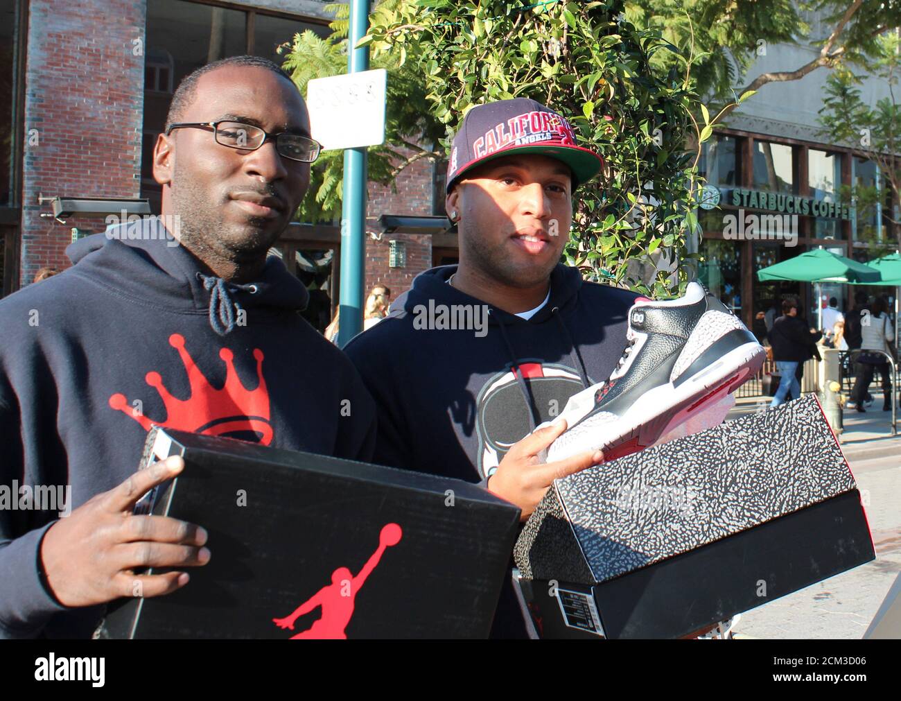 U.S. Navy Corpsmen Shawn Sykes (L) and Leon Clare show off the re-released Nike Air Jordan Retro 3 Black Cement sneakers purchased during a Black Friday sale in Santa Monica, January