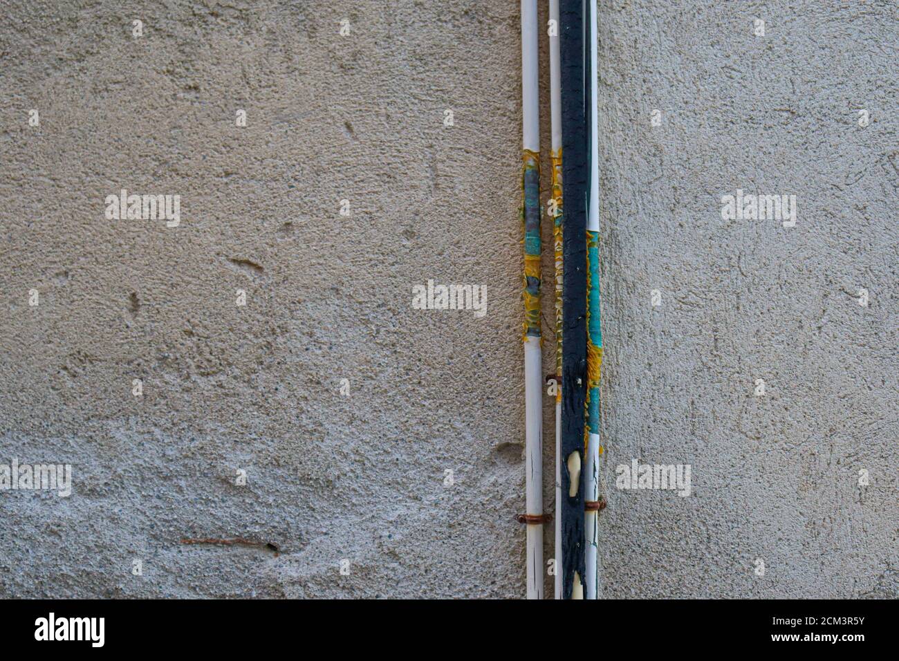 Pared de concreto con la vieja luz y tuberías de agua Foto de stock