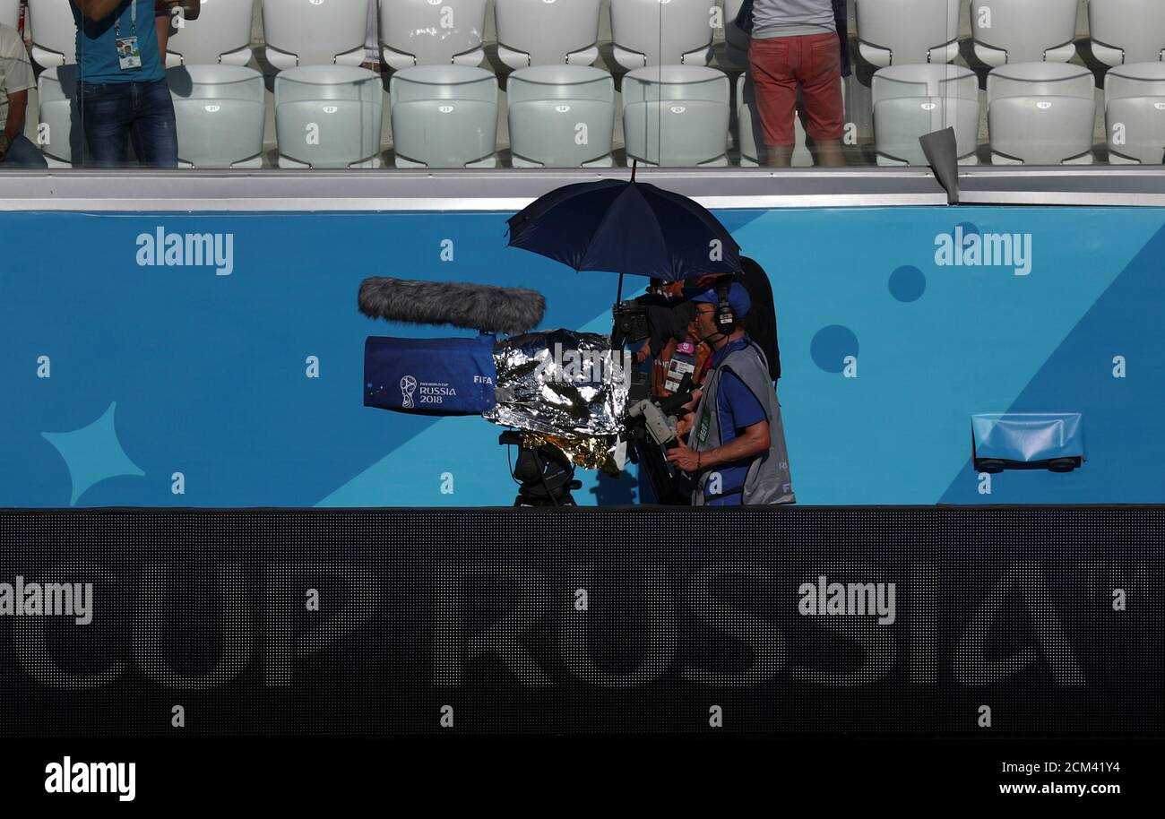 camarógrafo de TV utiliza un paraguas para protegerse del sol durante el partido de la Copa de Japón contra Polonia en el Arena en Volgograd, Rusia, el 28 de