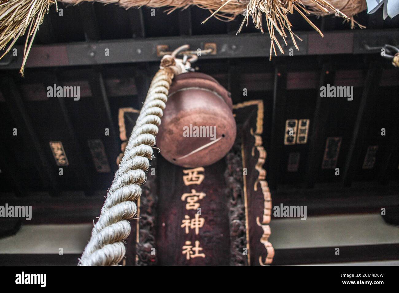Vista del ojo del gusano de la campana en el Santuario Nishinomiya Shinto en Nagano. El tablero de madera dice 'Nishinomiya Shrine' Foto de stock