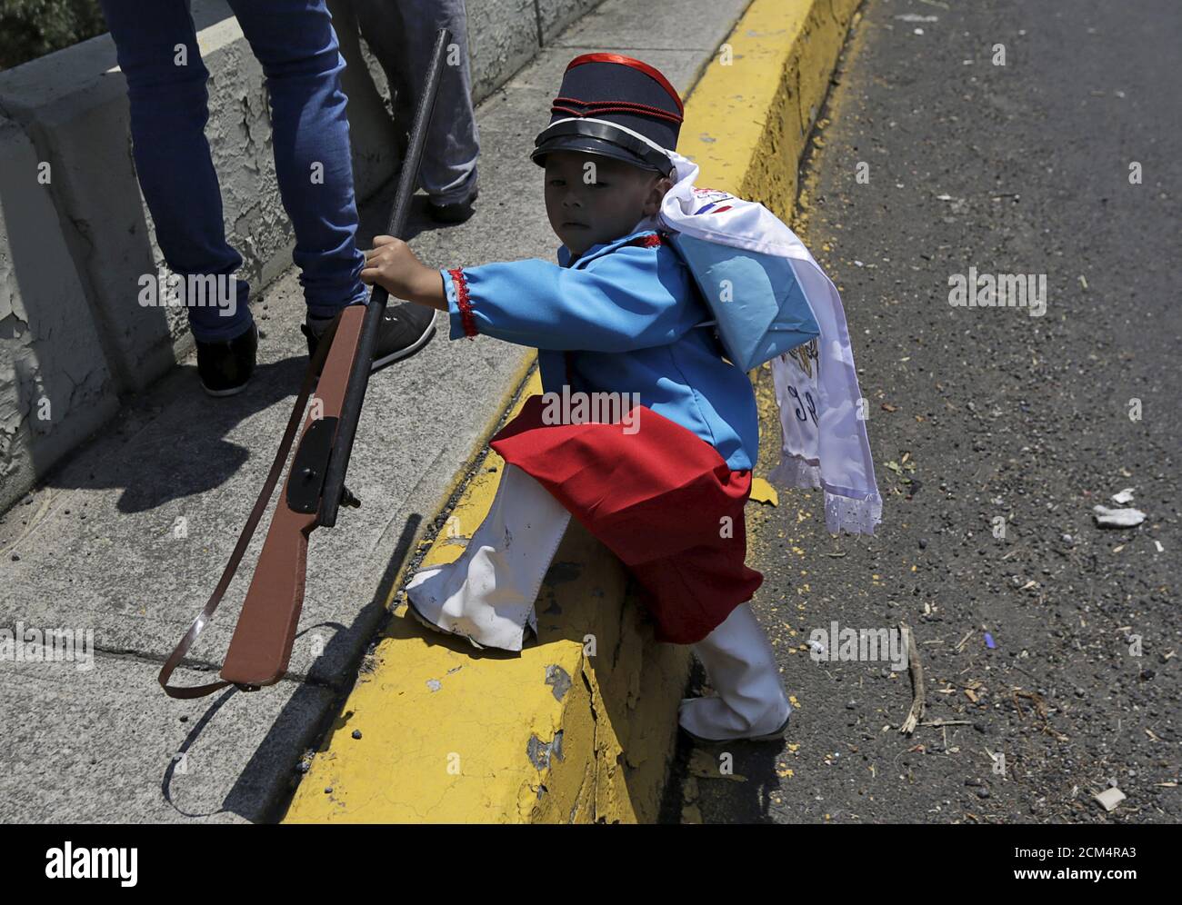 Un niño mexicano que lleva traje de época sostiene una escopeta casera  durante la re-promulgación de la batalla de Puebla, a lo largo de una calle  en la Ciudad de México, 5