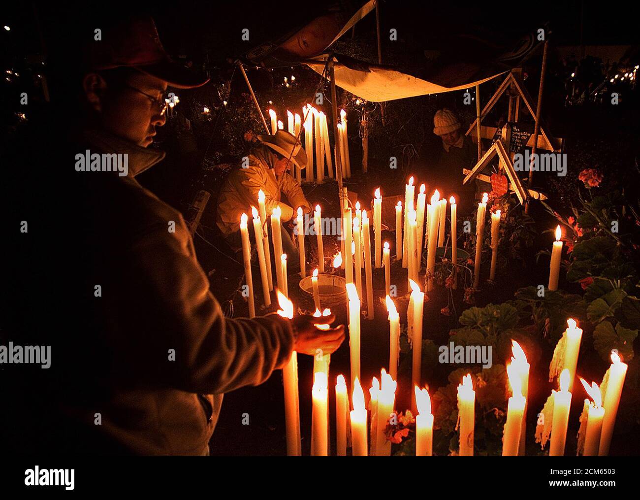 Un mexicano enciende una vela en la tumba de uno de sus familiares en