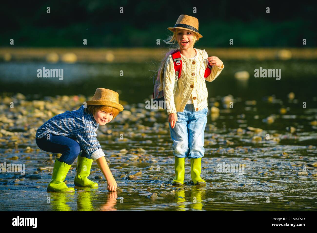 Una pequeña pareja enamorada jugando en el río. Niños caminando en el río. Viajes y trekking con niños pequeños. Niño activo explorando la naturaleza. Foto de stock