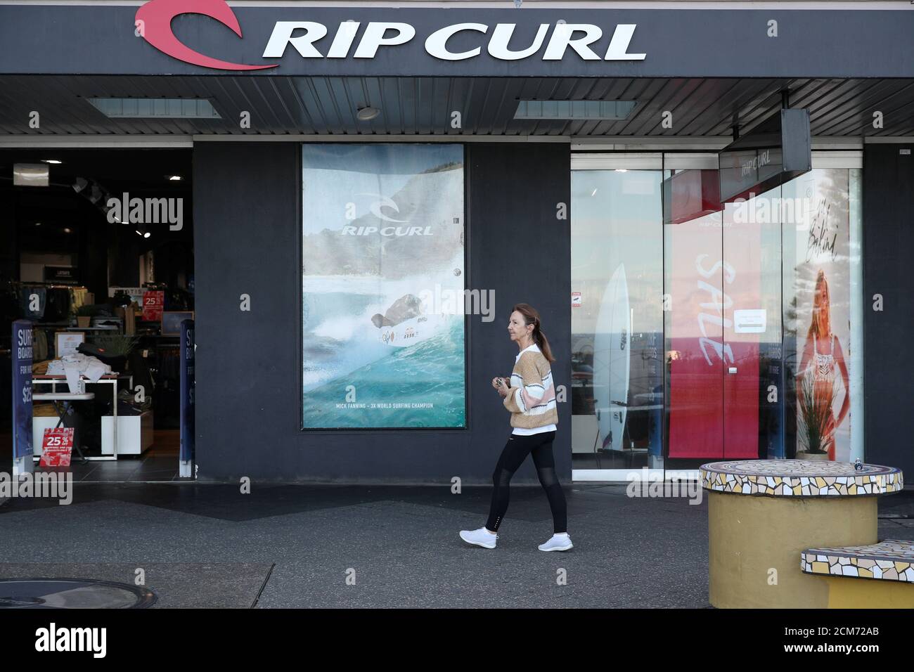 Una mujer pasa por una tienda de venta al por menor en medio de la reducción de las restricciones de la enfermedad por coronavirus (COVID-19) en Bondi Beach en Sydney, Australia, el 27 de mayo de 2020. REUTERS/Loren Elliott Foto de stock