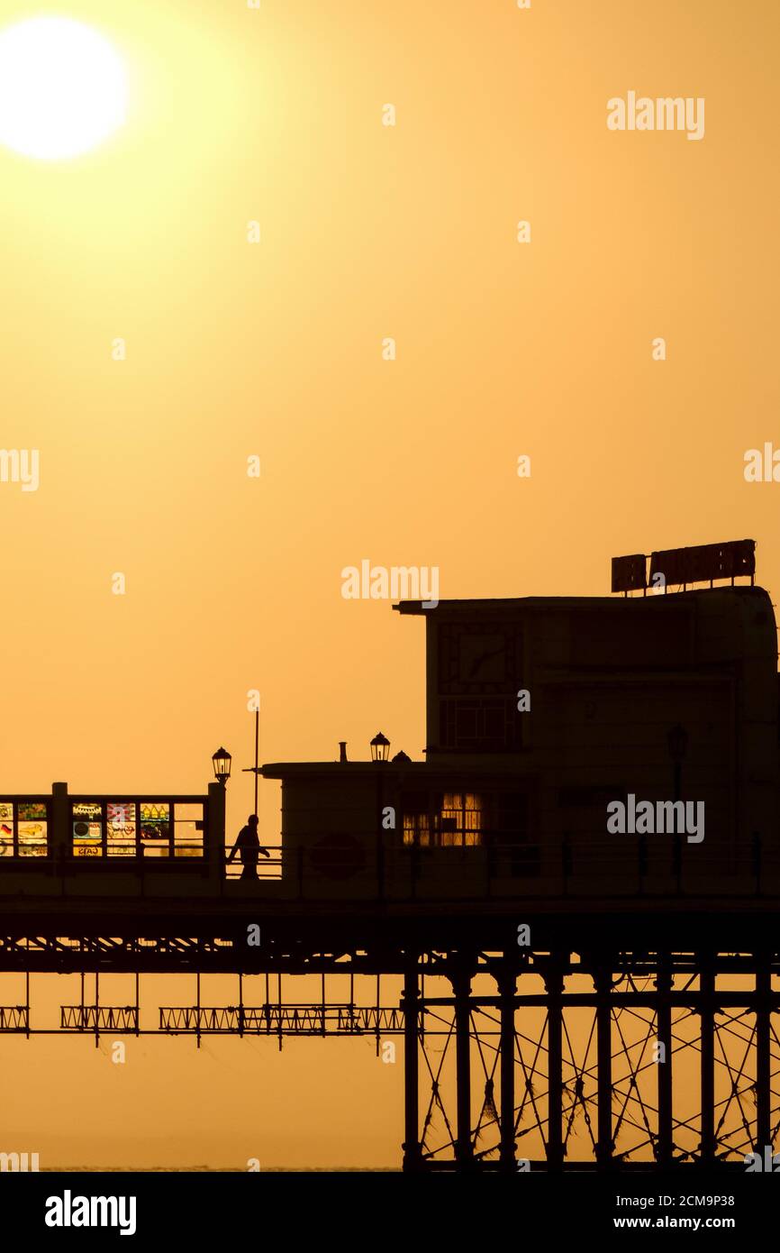 Worthing Beach, Worthing, Reino Unido. 17 de septiembre de 2020. Una persona que camina por el muelle Art Decó se perfila por el sol mientras se eleva en una cálida mañana de septiembre. Imagen de crédito: Julie Edwards/Alamy Live News Foto de stock