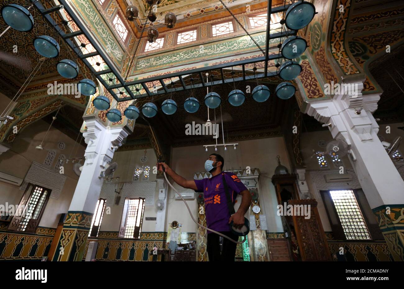 Un voluntario que lleva una máscara pulveriza desinfectante dentro de una mezquita, ya que está preparado para la oración después de ser reabierto, después del brote de la enfermedad del coronavirus (COVID-19), en el Cairo, Egipto, 26 de junio de 2020. REUTERS/Mohamed Abd el Ghany Foto de stock