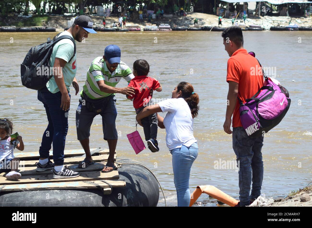 Un hombre ayuda a un migrante guatemalteco a embarcar con su hijo en una  balsa para cruzar a Ciudad Hidalgo, México, visto desde Tecun Uman,  Guatemala, 17 de julio de 2019. REUTERS/José