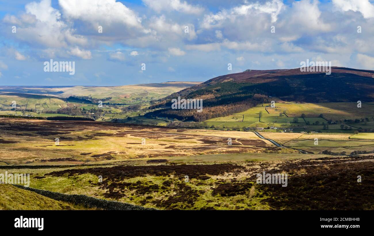 Paisaje de montaña (valle Wharfedale, pico Simon's Seat, colinas altas, fells, luz del sol, sombras en tierra, cielo azul) - Yorkshire Dales, Inglaterra Reino Unido Foto de stock