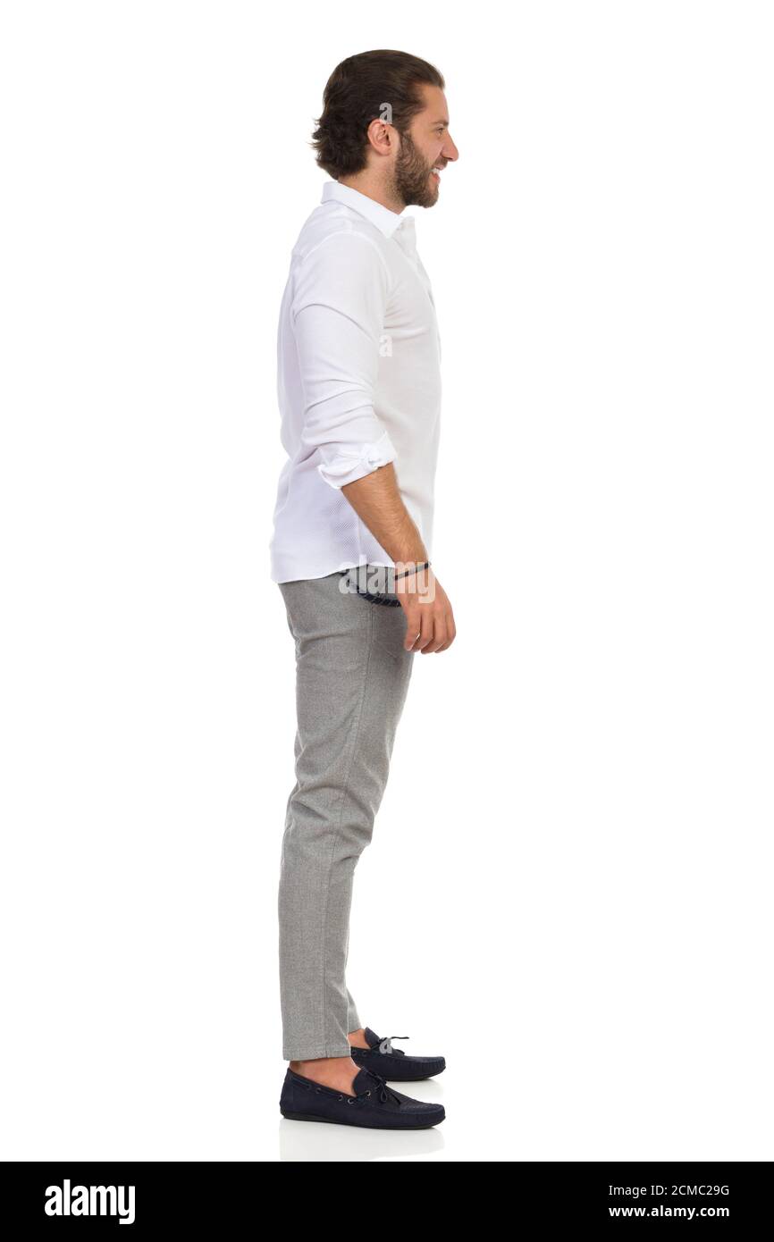 Un elegante con camisa blanca, grises y mocasines parado y mirando. Vista lateral. Estudio de duración completa sobre blanco Fotografía de stock - Alamy