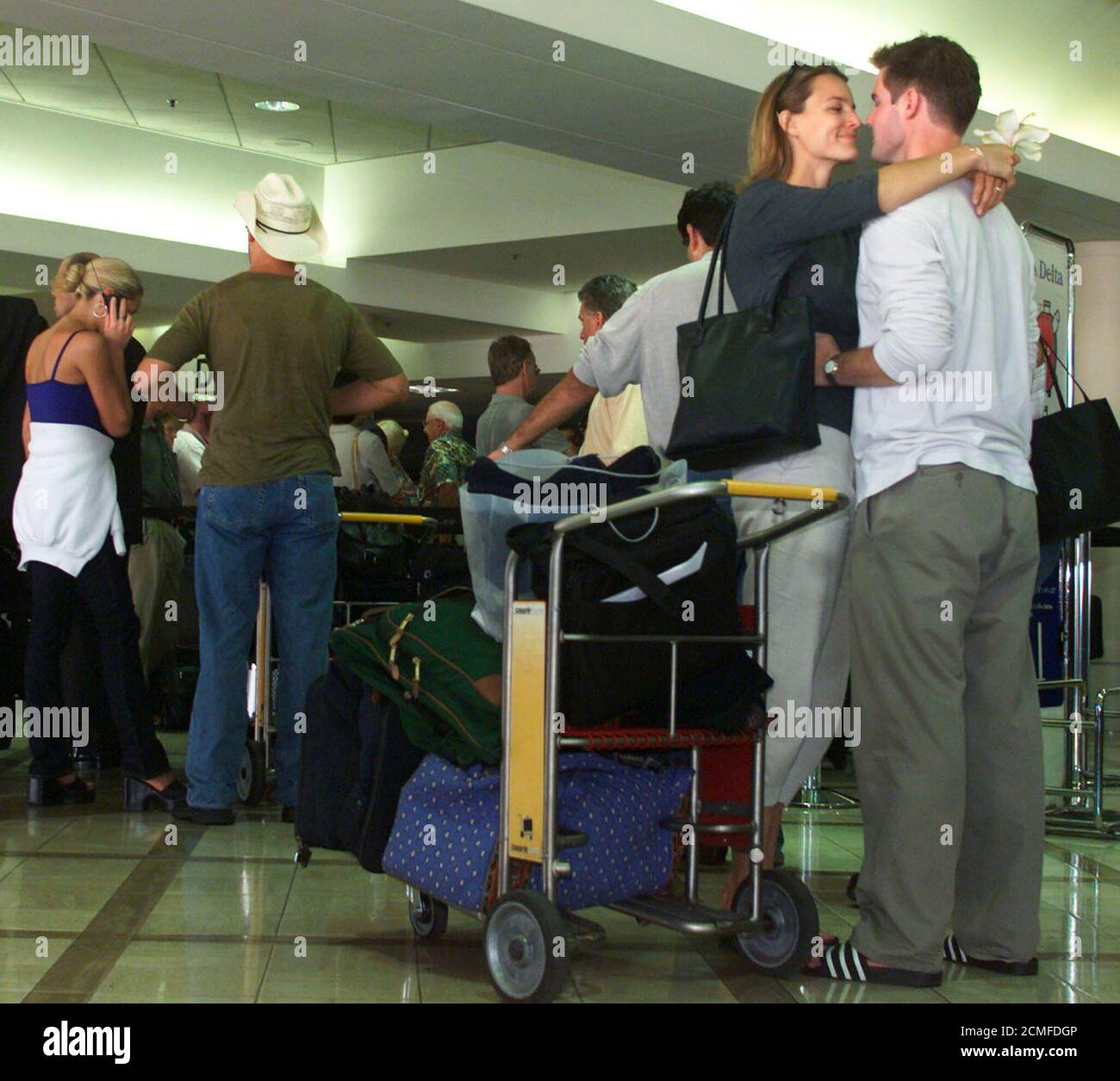 Carrie Bourdon (L) abraza a sean Kisker mientras esperan en línea para  facturar para su vuelo de Delta Airlines a Cinncinati en el Aeropuerto  Internacional de los Ángeles el 13 de septiembre