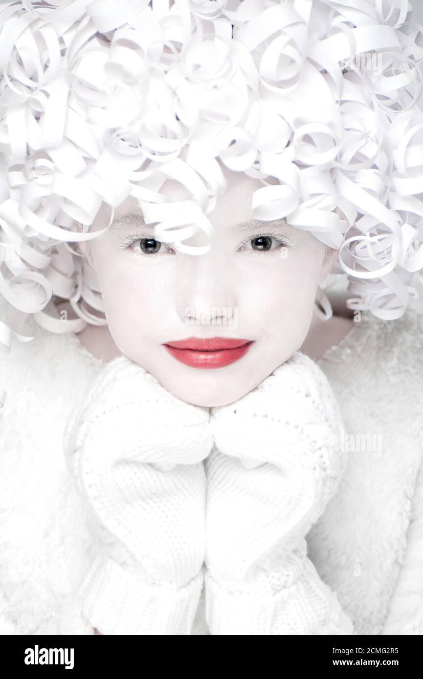 Retrato de encantador en manoplas con cara blanca cubierta de nieve. Foto de stock