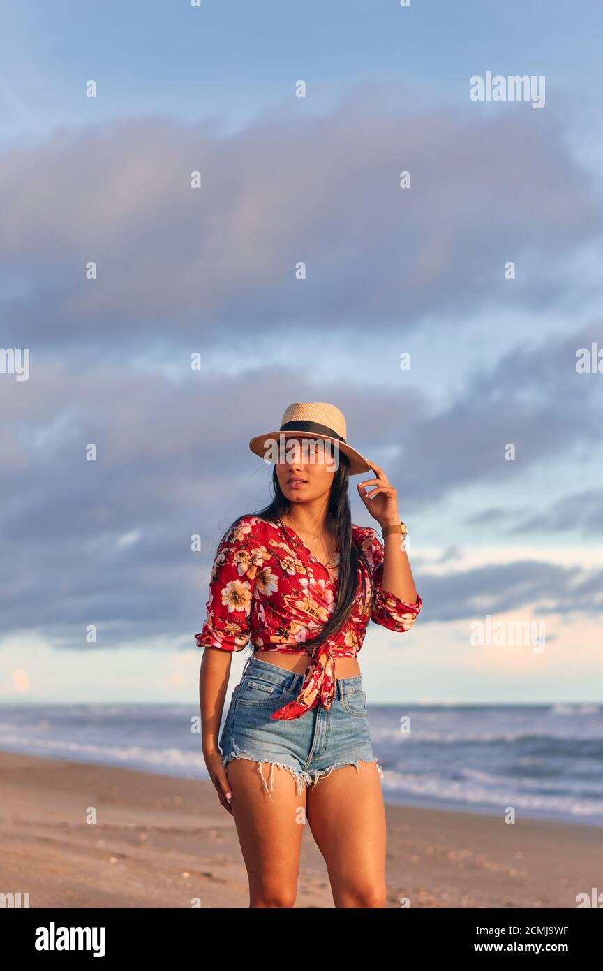 Una joven mujer maravillosa en la playa al atardecer Foto de stock