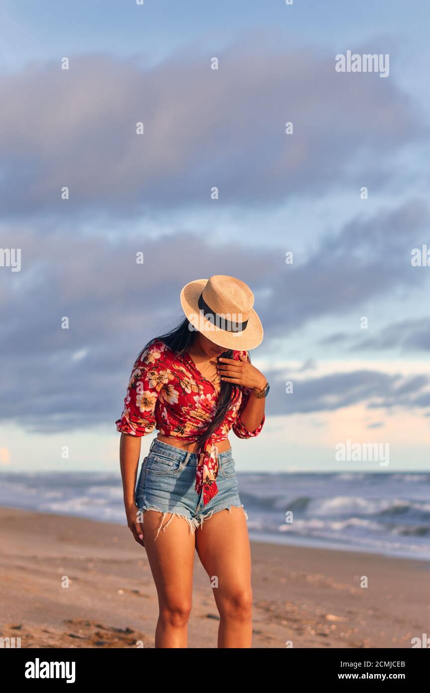 Una joven mujer maravillosa en la playa al atardecer Foto de stock