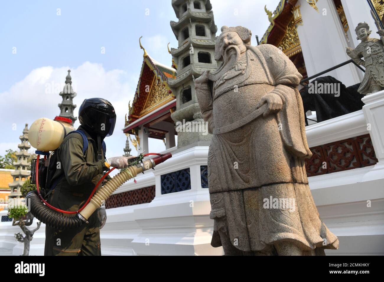 Un trabajador de la salud rocía desinfectante debido al brote de coronavirus en el interior del templo Wat Suthat Thepwararam en Bangkok, Tailandia 17 de marzo de 2020. REUTERS/Chalinee Thirasupa Foto de stock