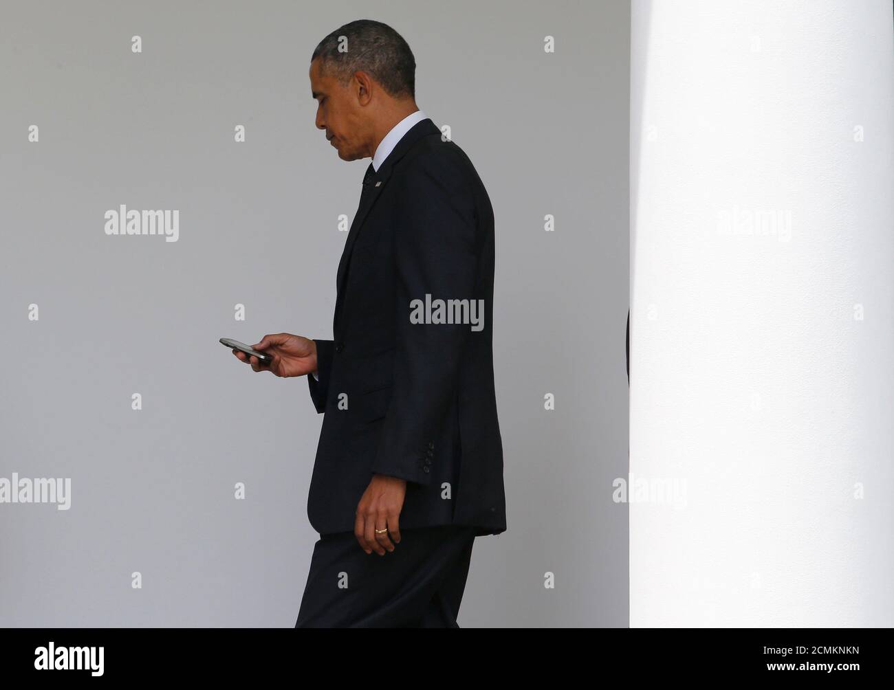 El presidente Barack Obama revisa su smartphone BlackBerry al regresar de un viaje a Nueva York para asistir a la inauguración del Museo Nacional Conmemorativo del 11 de septiembre en Nueva York, mientras camina hacia el ala oeste de la Casa Blanca en Washington, el 15 de mayo de 2014. REUTERS/JIM BOURG (ESTADOS UNIDOS - TAGS: POLÍTICA TPX IMÁGENES DEL DÍA) Foto de stock