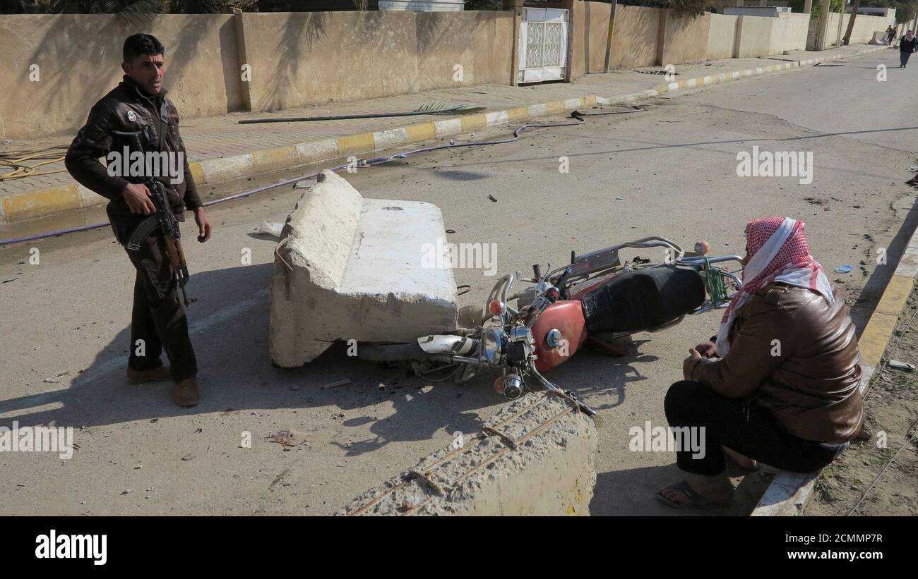 Un hombre permanece en guardia cerca de la casa del prominente legislador musulmán sunita Ahmed al-Alwani después de enfrentamientos con las fuerzas de seguridad iraquíes en el centro de Ramadi, el 28 de diciembre de 2013. Las fuerzas de seguridad iraquíes arrestaron a Alwani, un defensor de las protestas contra el gobierno, en una redada en su casa en la provincia occidental de Anbar, que provocó enfrentamientos en los que murieron al menos cinco personas, dijeron las fuentes de la policía. Dijeron que entre los muertos en los combates había tres guardaespaldas de Alwani, su hermana y su hermano. REUTERS/Ali al-Mashhadani (IRAK - Tags: POLÍTICA DISTURBIOS CIVILES) Foto de stock