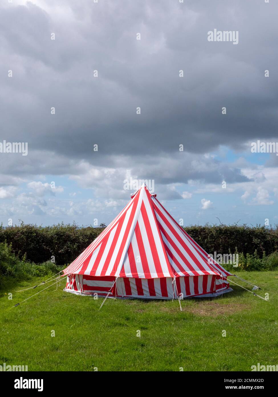 Una tienda de rayas rojas y blancas de colores brillantes en un Un camping en el Reino Unido Foto de stock